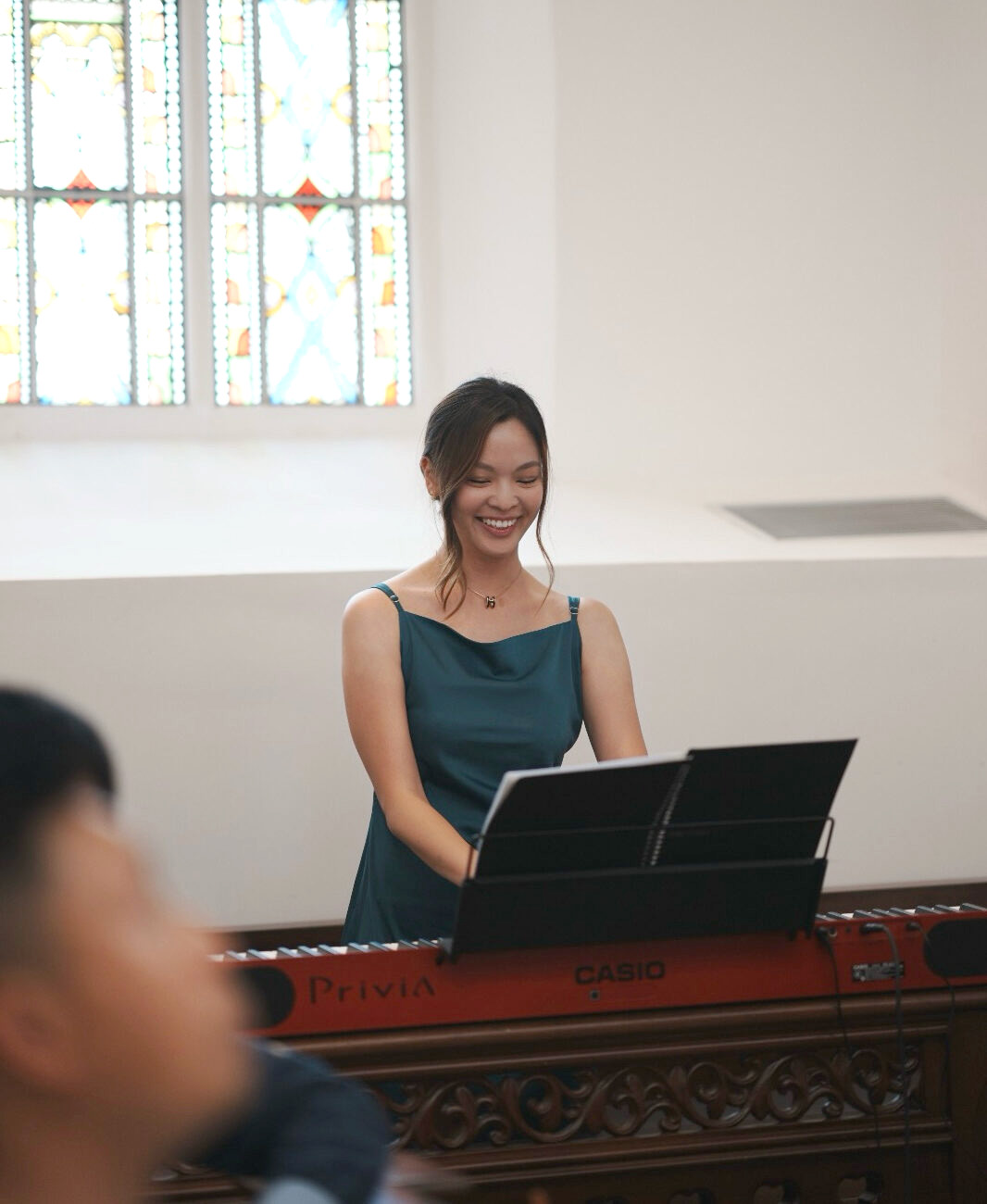 Flora smiling while playing the piano